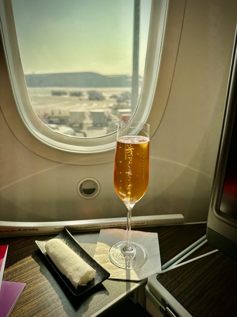 Glass of champagne after boarding Qatar Airways Business Class cabin.